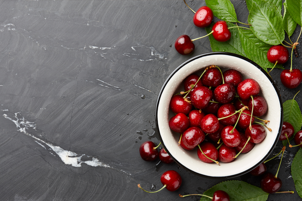 slate countertop with cherries in a bowl